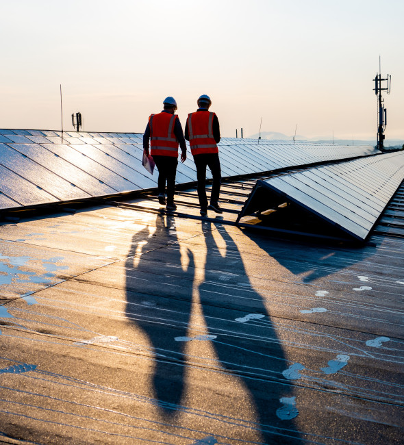 Two energy workers walking near solar panels