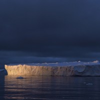 Iceberg in the ocean at sunset